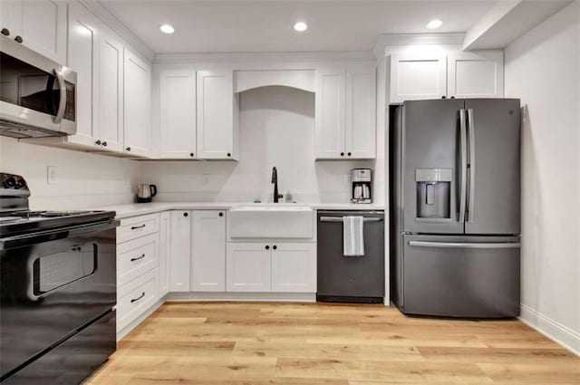 kitchen with white cabinetry, appliances with stainless steel finishes, sink, and light hardwood / wood-style flooring