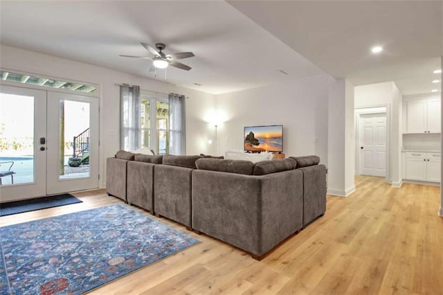 living room featuring ceiling fan, light wood-type flooring, and french doors