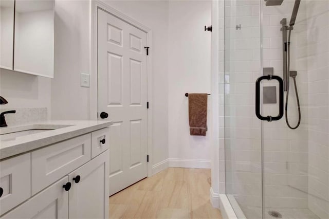 bathroom with vanity, hardwood / wood-style floors, and a shower with shower door