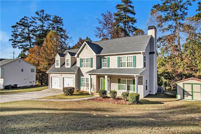 view of front of property featuring a front lawn, central AC, covered porch, a garage, and a storage unit