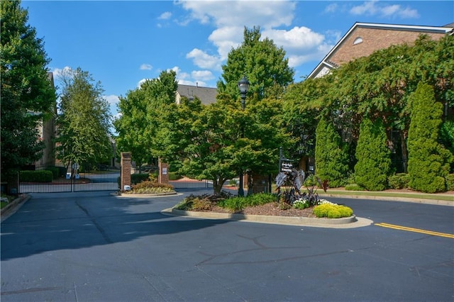 661 Lockton Pl, Sandy Springs, GA 30342 - view of asphalt street with curbs, a gate, street lights, and a gated entry