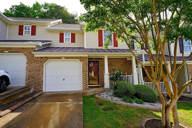 townhome / multi-family property featuring a standing seam roof, brick siding, concrete driveway, an attached garage, and a porch