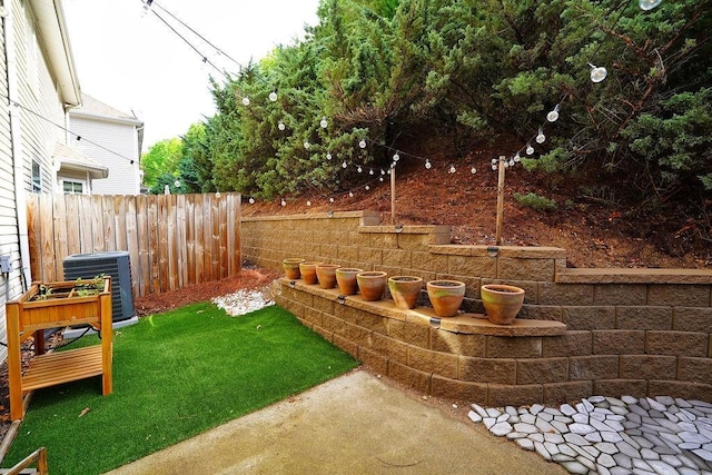 view of yard with central air condition unit and fence