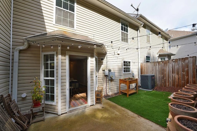 back of property with central air condition unit and fence