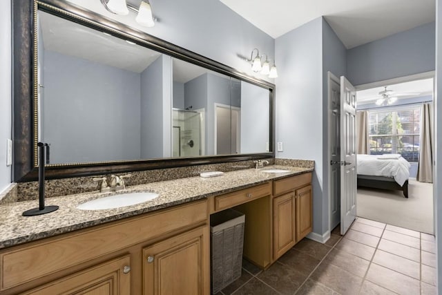 ensuite bathroom featuring a sink, double vanity, a shower stall, and tile patterned floors