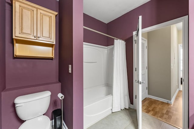 full bathroom with tile patterned floors, toilet, shower / tub combo, and baseboards