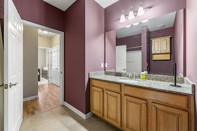 bathroom featuring tile patterned floors, baseboards, and vanity