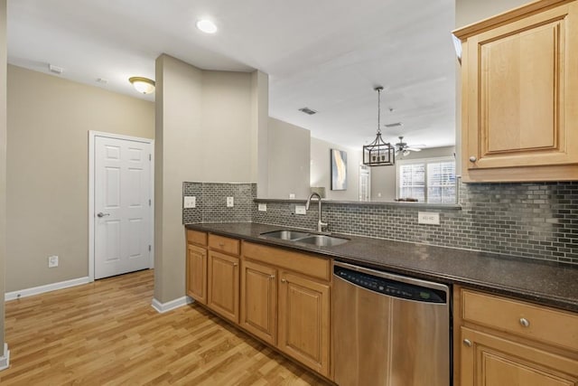 kitchen with baseboards, a sink, light wood-style floors, stainless steel dishwasher, and tasteful backsplash