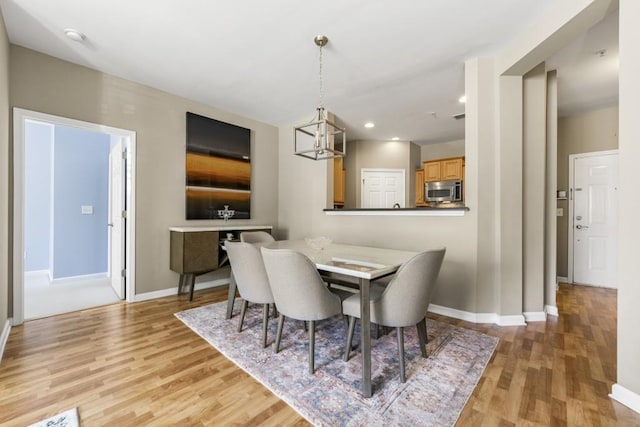 dining room featuring recessed lighting, a chandelier, baseboards, and light wood-style flooring