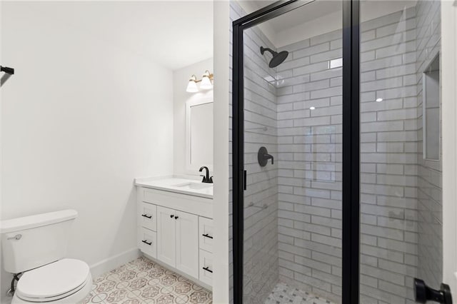 bathroom with baseboards, a shower stall, vanity, and toilet