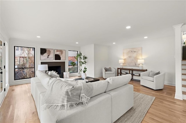 living area featuring light wood finished floors, recessed lighting, and a fireplace