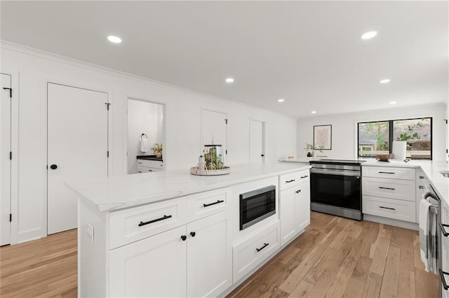 kitchen featuring light wood finished floors, recessed lighting, white cabinetry, and stainless steel appliances