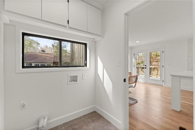 laundry area featuring baseboards, laundry area, french doors, wood finished floors, and electric dryer hookup