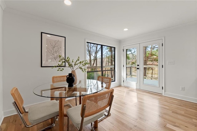 dining space with french doors, plenty of natural light, light wood-style floors, and baseboards