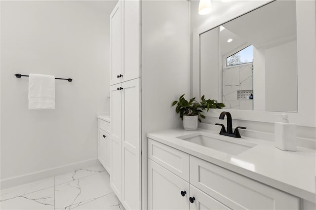 full bathroom featuring vanity, baseboards, marble finish floor, and walk in shower