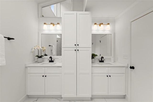 full bathroom featuring double vanity, crown molding, marble finish floor, and a sink