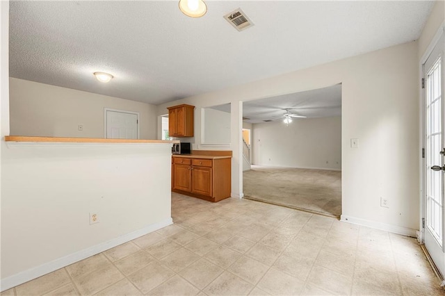 85 Old Gettysburg Way, Dallas, GA 30157 - kitchen featuring ceiling fan, brown cabinets, baseboards, open floor plan, and a textured ceiling