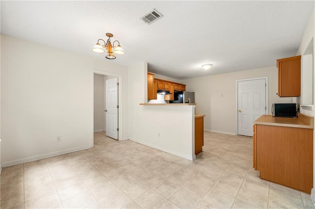 85 Old Gettysburg Way, Dallas, GA 30157 - kitchen with appliances with stainless steel finishes, under cabinet range hood, light countertops, a peninsula, and a textured ceiling