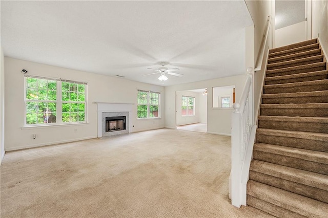 85 Old Gettysburg Way, Dallas, GA 30157 - unfurnished living room with a ceiling fan, light carpet, a premium fireplace, stairway, and baseboards