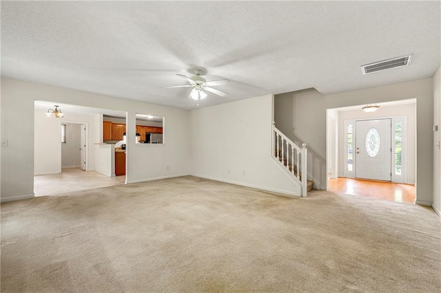85 Old Gettysburg Way, Dallas, GA 30157 - unfurnished living room with light carpet, stairway, a ceiling fan, baseboards, and a textured ceiling