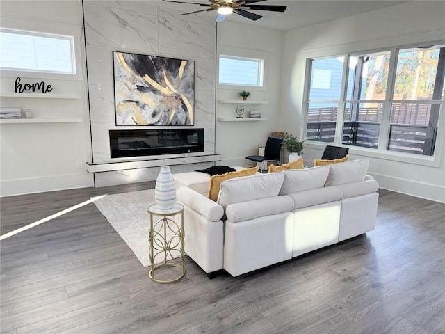 living room with dark hardwood / wood-style floors, ceiling fan, and a fireplace