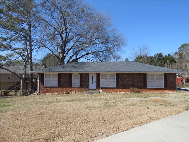 ranch-style home featuring a front lawn and brick siding