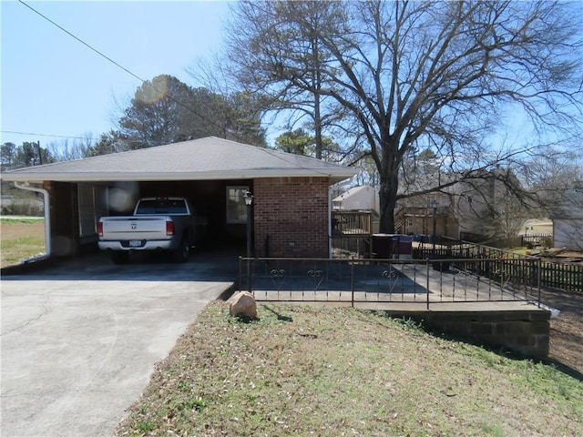 view of home's exterior featuring a carport, concrete driveway, brick siding, and a shingled roof