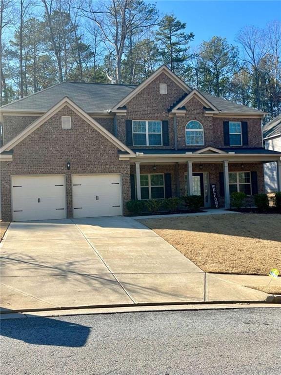 2208 Ginger Lake Dr NE, Conyers, GA 30013 - view of front of property with brick siding, an attached garage, concrete driveway, and a porch