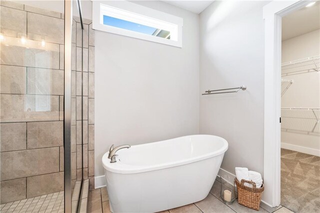 bathroom featuring tile patterned flooring and shower with separate bathtub