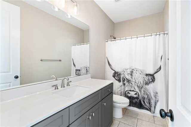 bathroom with tile patterned flooring, vanity, and toilet