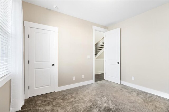 unfurnished bedroom featuring dark carpet