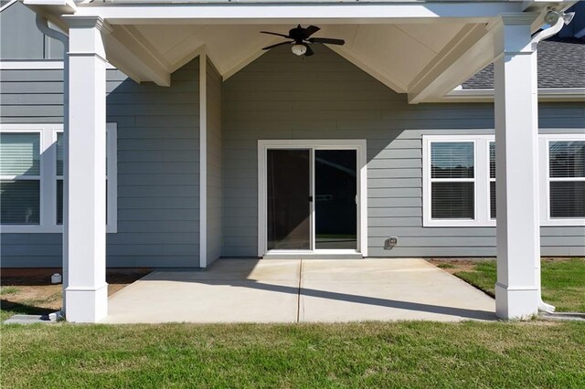 exterior space featuring a patio, ceiling fan, and a lawn