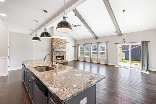 kitchen featuring ceiling fan, sink, dark wood-type flooring, an island with sink, and pendant lighting