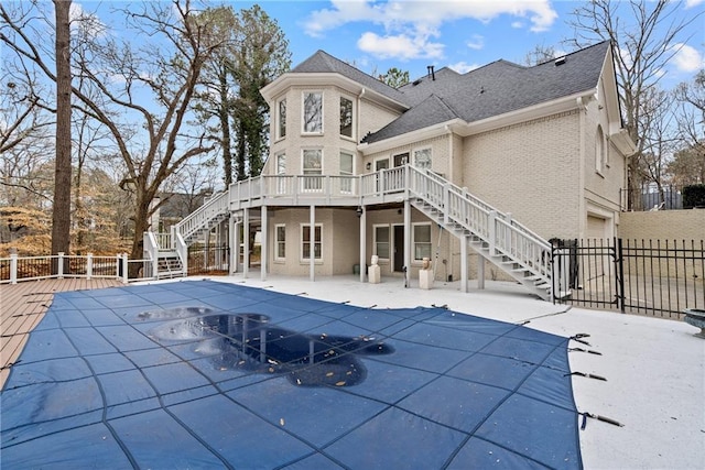 rear view of property featuring a garage and a pool side deck