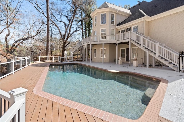 view of swimming pool with a patio, stairway, a wooden deck, and a fenced in pool