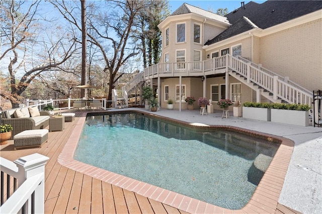 view of pool featuring a fenced in pool, a patio, stairway, a wooden deck, and an outdoor living space