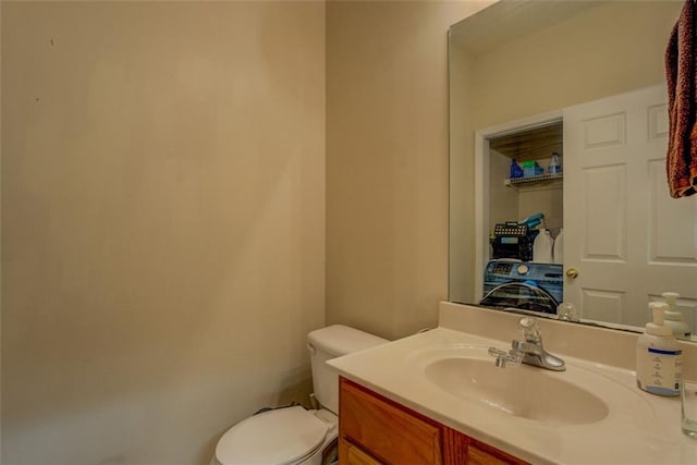 bathroom with washer / dryer, vanity, and toilet