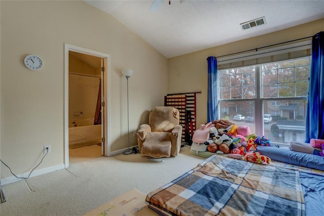 carpeted bedroom with vaulted ceiling and ensuite bath