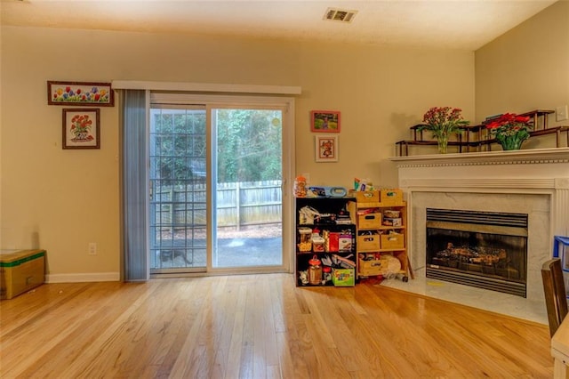 interior space with a high end fireplace and hardwood / wood-style flooring