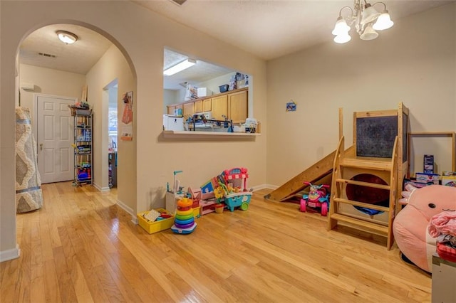 playroom with a chandelier and light hardwood / wood-style flooring