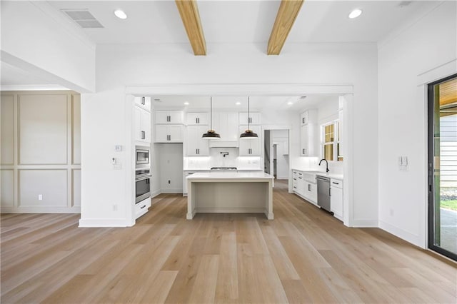 3601 Perry Smith Rd, Monroe, GA 30656 - kitchen with appliances with stainless steel finishes, light countertops, light wood-type flooring, beamed ceiling, and visible vents