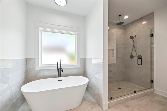 3601 Perry Smith Rd, Monroe, GA 30656 - bathroom with a freestanding tub, a wainscoted wall, a shower stall, and tile walls