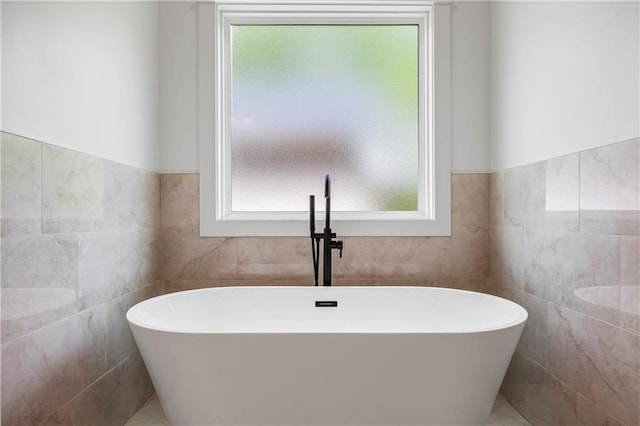 3601 Perry Smith Rd, Monroe, GA 30656 - bathroom featuring a freestanding bath, tile walls, and a wealth of natural light
