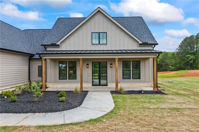 3601 Perry Smith Rd, Monroe, GA 30656 - view of front of home featuring covered porch, board and batten siding, a standing seam roof, a front lawn, and a shingled roof
