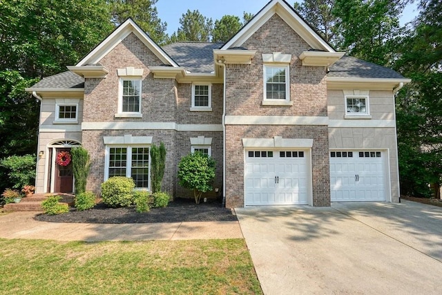 921 Laurel Crest Dr, Woodstock, GA 30189 - view of front facade featuring concrete driveway, an attached garage, a shingled roof, and brick siding