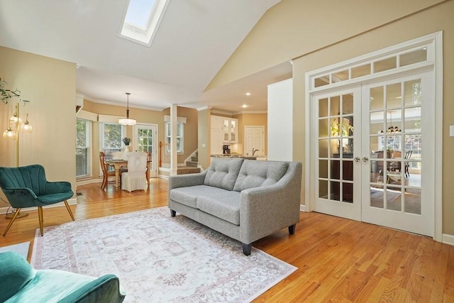 921 Laurel Crest Dr, Woodstock, GA 30189 - living area with french doors, lofted ceiling, light wood-style floors, a skylight, and crown molding