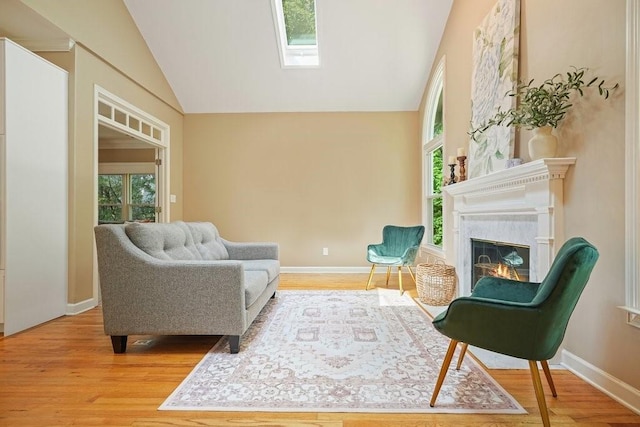 921 Laurel Crest Dr, Woodstock, GA 30189 - living area featuring wood finished floors, vaulted ceiling, plenty of natural light, and a premium fireplace