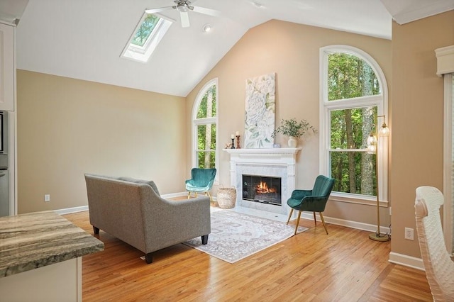 921 Laurel Crest Dr, Woodstock, GA 30189 - living room with a fireplace with flush hearth, a ceiling fan, vaulted ceiling, light wood-style floors, and healthy amount of natural light