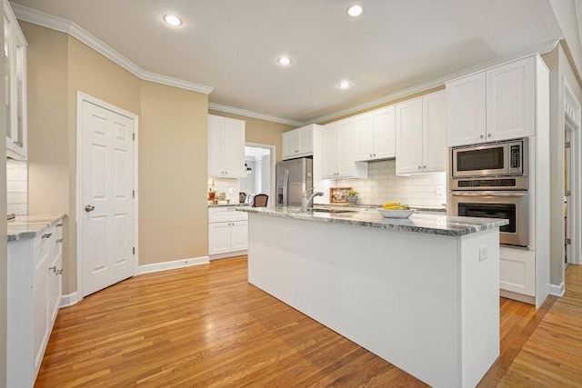 921 Laurel Crest Dr, Woodstock, GA 30189 - kitchen featuring stainless steel appliances, crown molding, backsplash, light wood-type flooring, and white cabinetry
