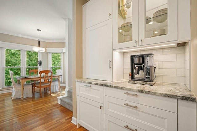 921 Laurel Crest Dr, Woodstock, GA 30189 - bar area featuring decorative backsplash, crown molding, light wood finished floors, and decorative light fixtures
